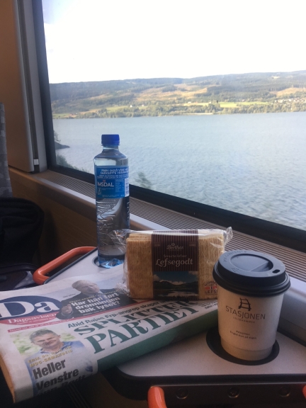 På toget fra Lillehammer til Oslo. Norsk vann og vestlandslefse, avis og kaffe.